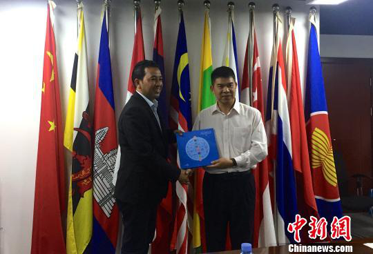 中國—東盟博覽會秘書處副秘書長黃平西（右）與柬埔寨新聞部新聞與傳播總司副總司長春占皮侖（左）互贈禮物。